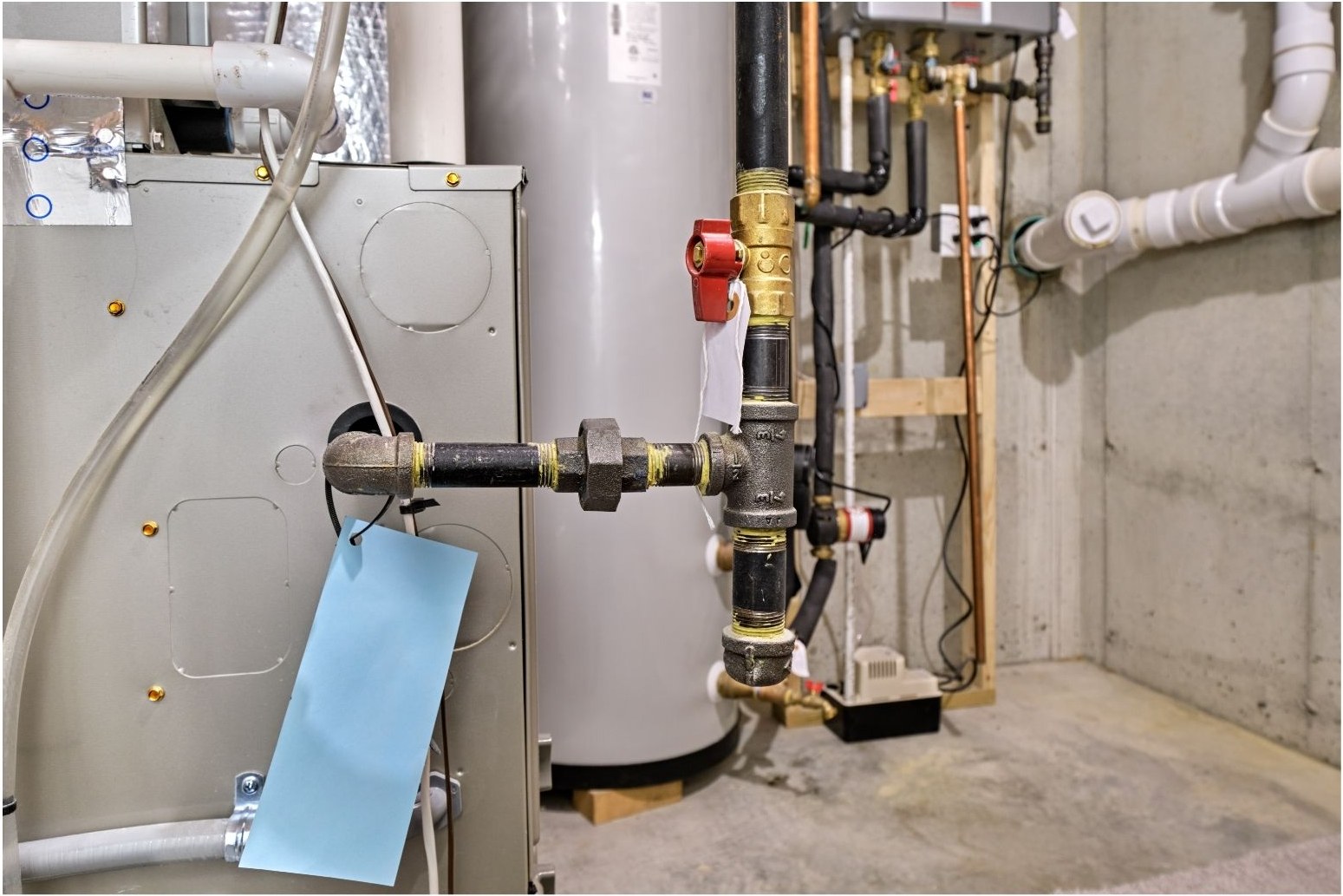 furnace repair Branson MO - Now! Heating & Cooling service tag on a gas furnace and gas line connections in a basement utility room