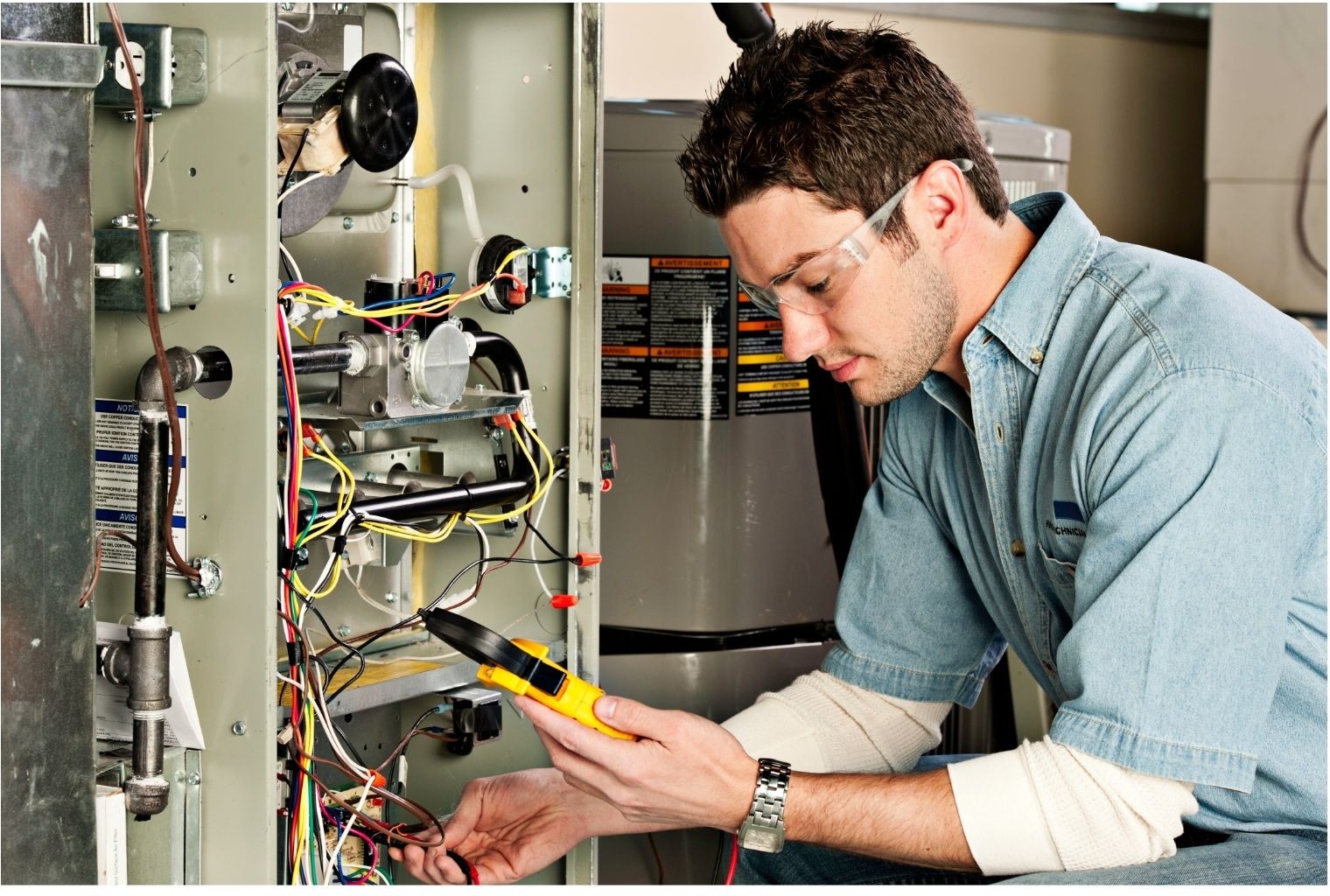 furnace tune-up Branson MO - Now! Heating & Cooling technician using a multimeter to inspect furnace wiring and gas valve