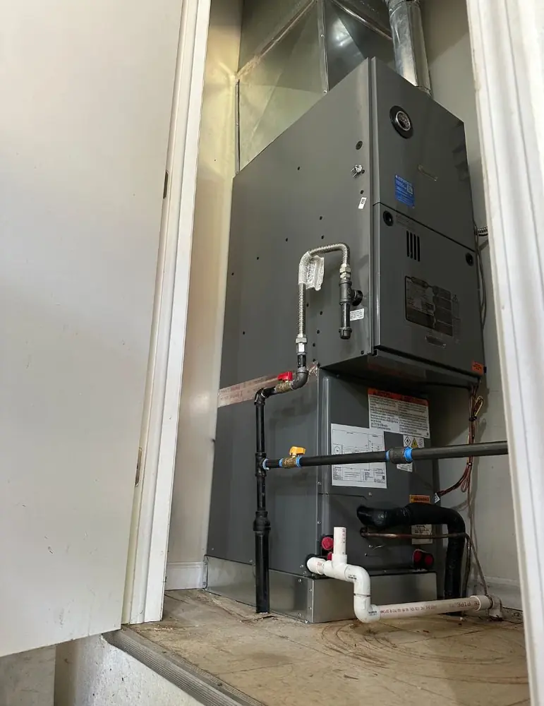 New gas furnace installed in a utility closet with PVC venting