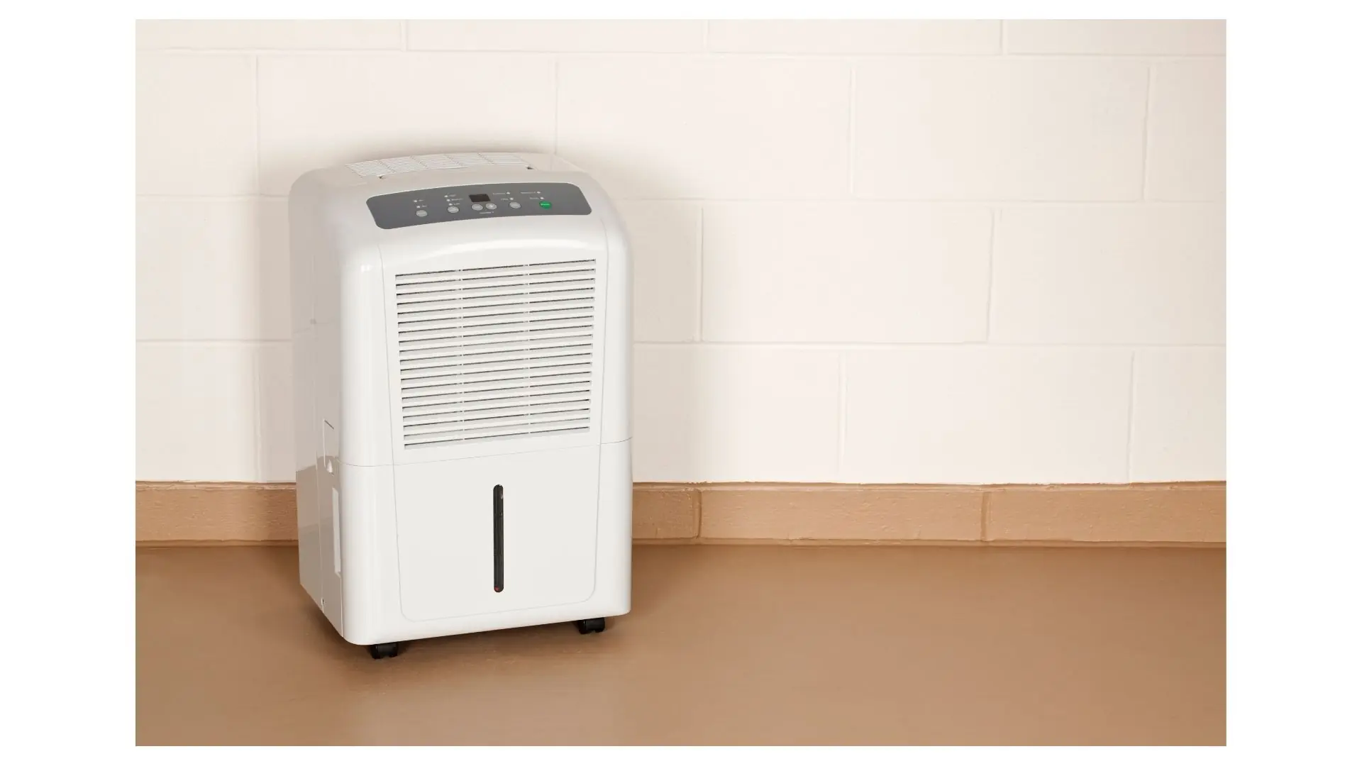 Dehumidifier standing on a floor against a wall